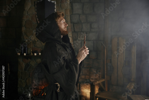 Obraz na płótnie Faithful priest in robe hood praying with rosary beads and cross w salonie