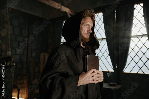 Obraz na płótnie Medieval priest holding closed bible book and rosary beads in hands closeup w salonie