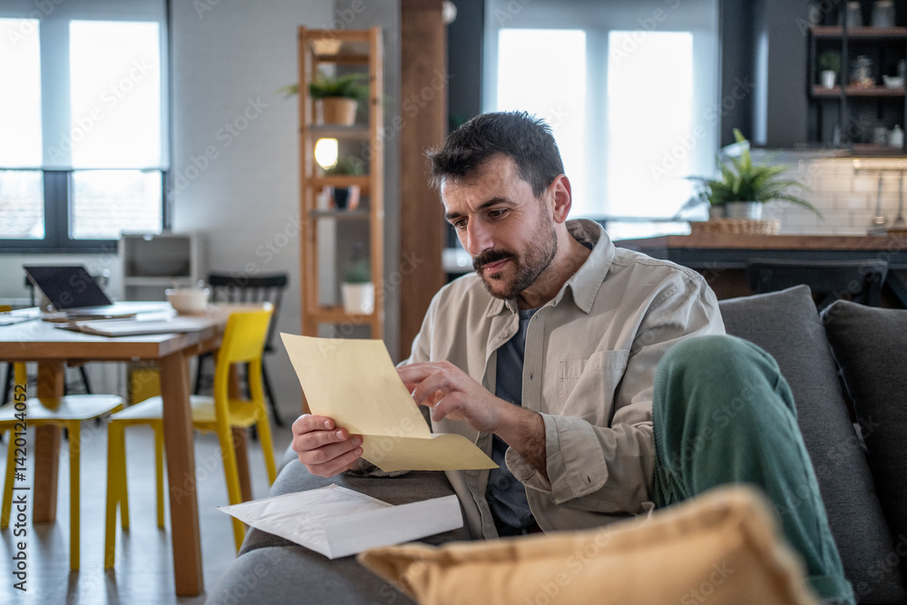 Fototapeta premium Man reviewing documents in modern home office