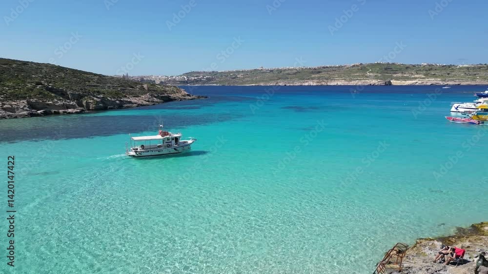 ummer Vacation in Malta: Boat in Crystal Clear Water of Comino Island ummer Vacation in Malta: Boat in Crystal Clear Water of Comino Island