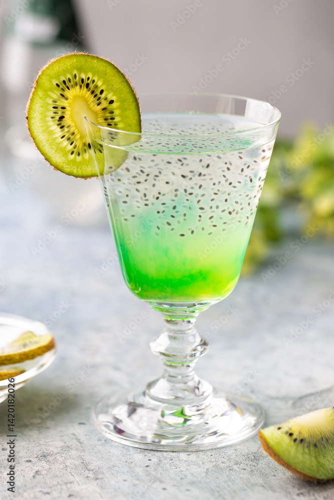 Cold cocktail kiwi drink in a glass with fresh fruits on gray background