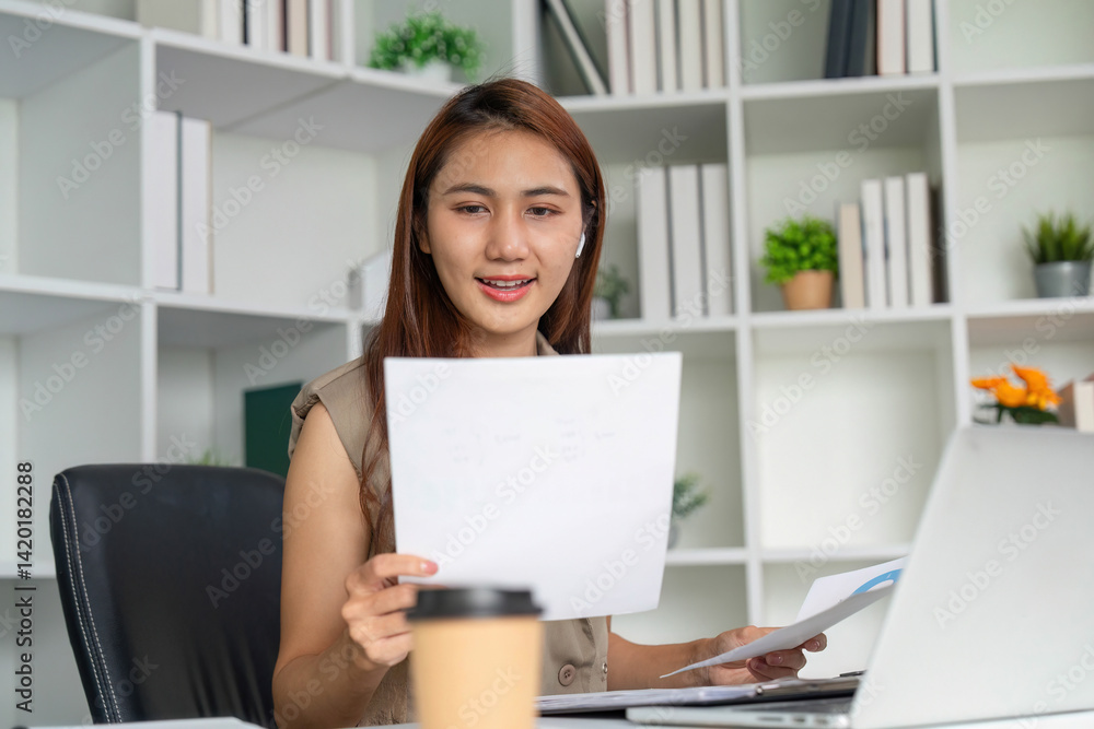 Focused Work and Productivity. A woman reviewing documents while seated at a modern office desk, showcasing her dedication to her tasks. Focused Work and Productivity. A woman reviewing documents while seated at a modern office desk, showcasing her dedication to her tasks.
