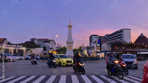 Yogyakarta, Indonesia - April 19, 2025. Tugu Yogyakarta sunset in the afternoon with traffic. Tugu Jogja is one of the landmarks of Yogyakarta.