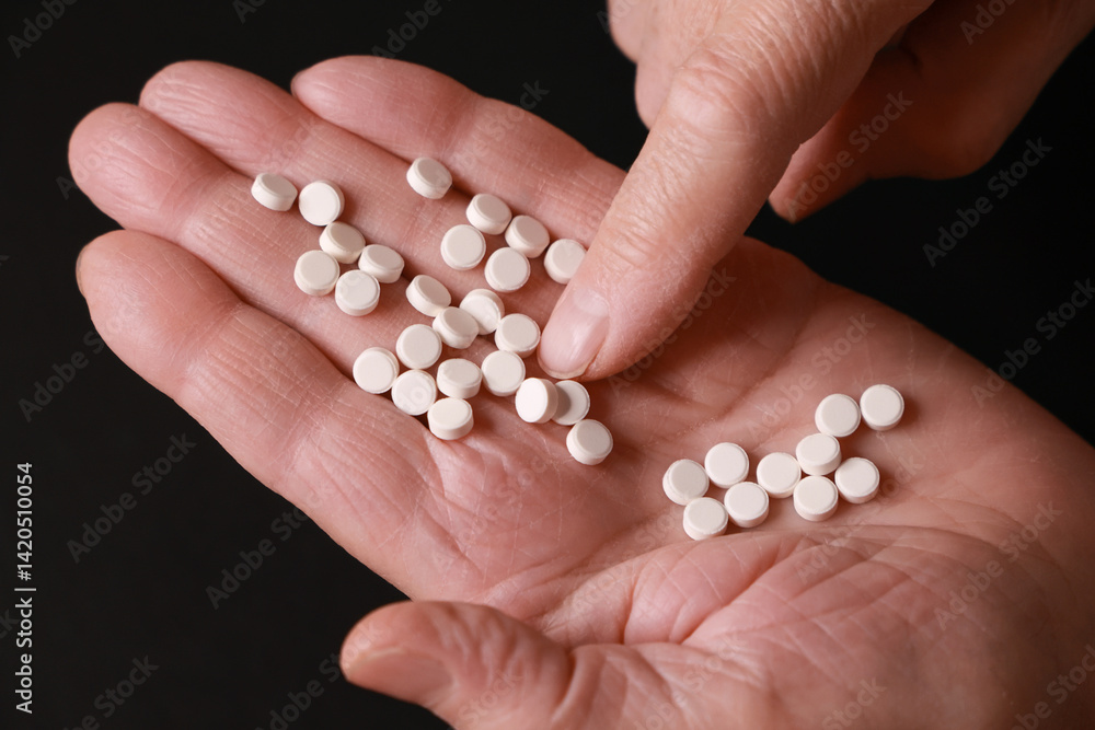 An Overhead View Of White, Round Pills Resting On A Hand Against A Dark Background, Highlighting Medication And Health Themes. An Overhead View Of White, Round Pills Resting On A Hand Against A Dark Background, Highlighting Medication And Health Themes.