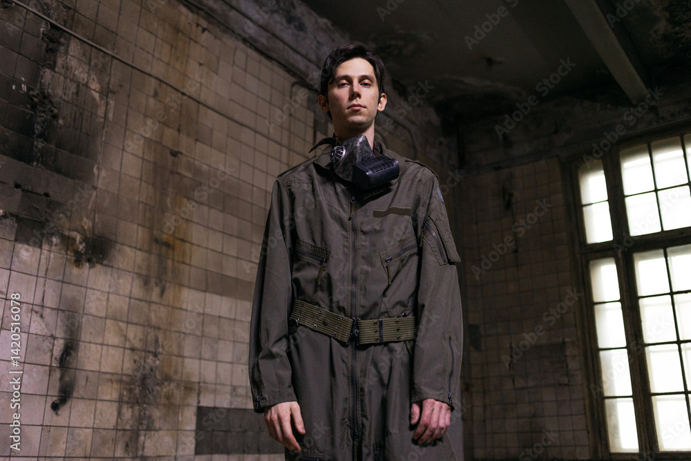 Naklejka premium Tactical operator in military jumpsuit wearing gas mask, gritty portrait in destroyed urban setting
