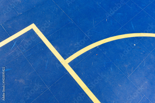 Geometric lines on a vibrant blue sports court surface, highlighting a basketball or futsal boundary with strong visual contrast. Stock photo