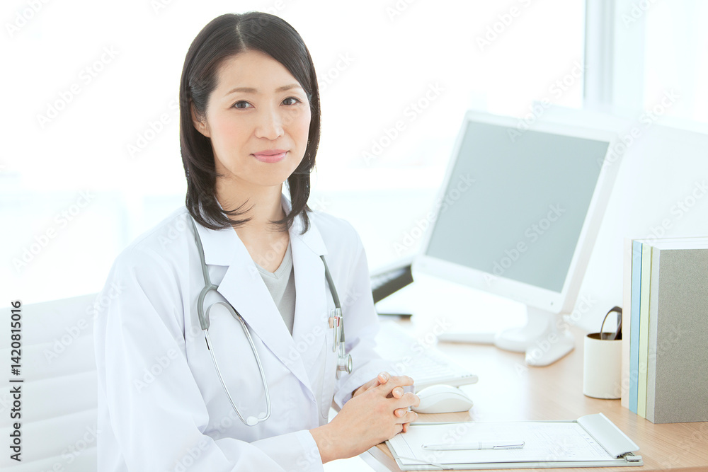 デスクに座る白衣の女性医師