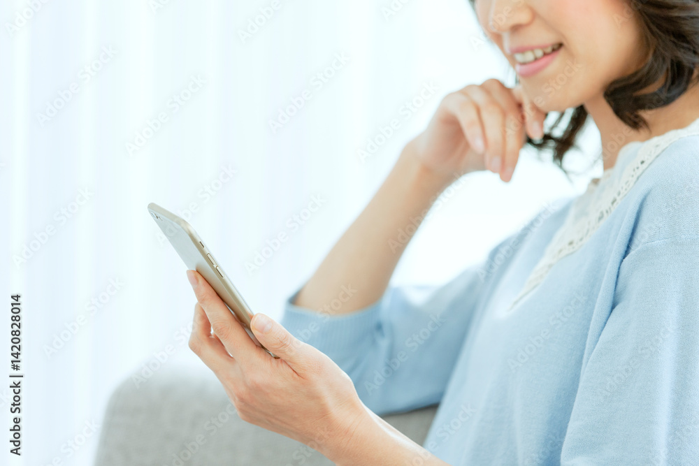 スマートフォンを見る中年女性 スマートフォンを見る中年女性