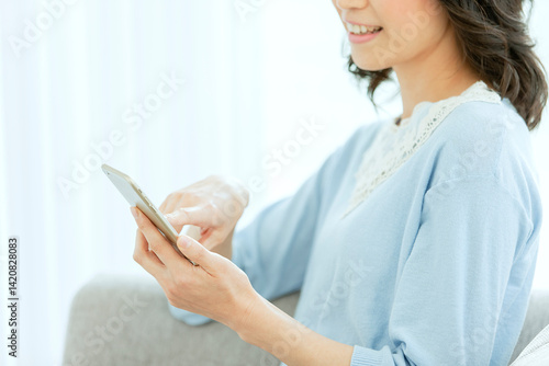 スマートフォンを見る中年女性