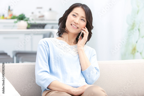 スマートフォンで電話する中年女性
