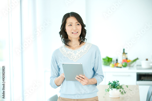 タブレットを操作する中年女性