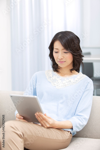 タブレットを操作する中年女性