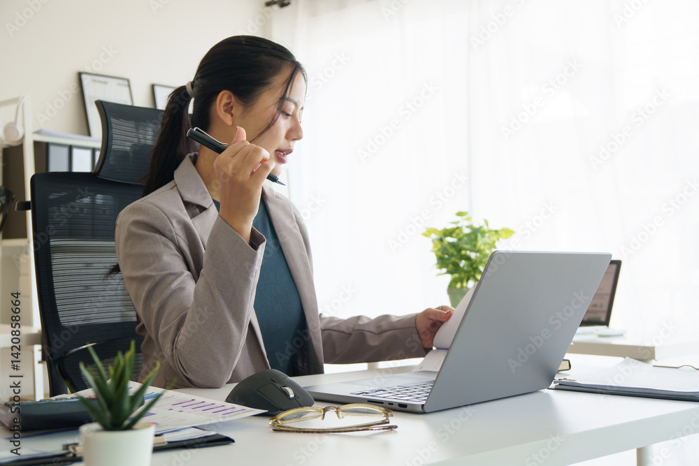 Businesswoman calculating budget and reviewing financial reports at desk in modern office. Businesswoman calculating budget and reviewing financial reports at desk in modern office.