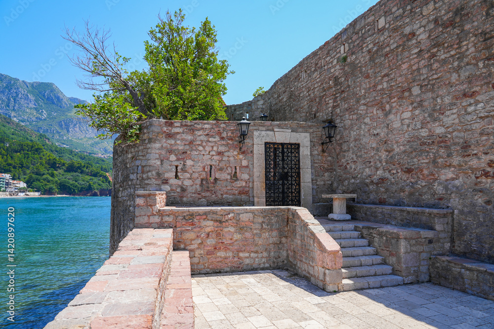 Gateway of Sveti Stefan, a medieval village located on a small island connected to the mainland by a narrow tombolo (sandy isthmus) in the bay of Budva along the Adriatic Coast, Montenegro