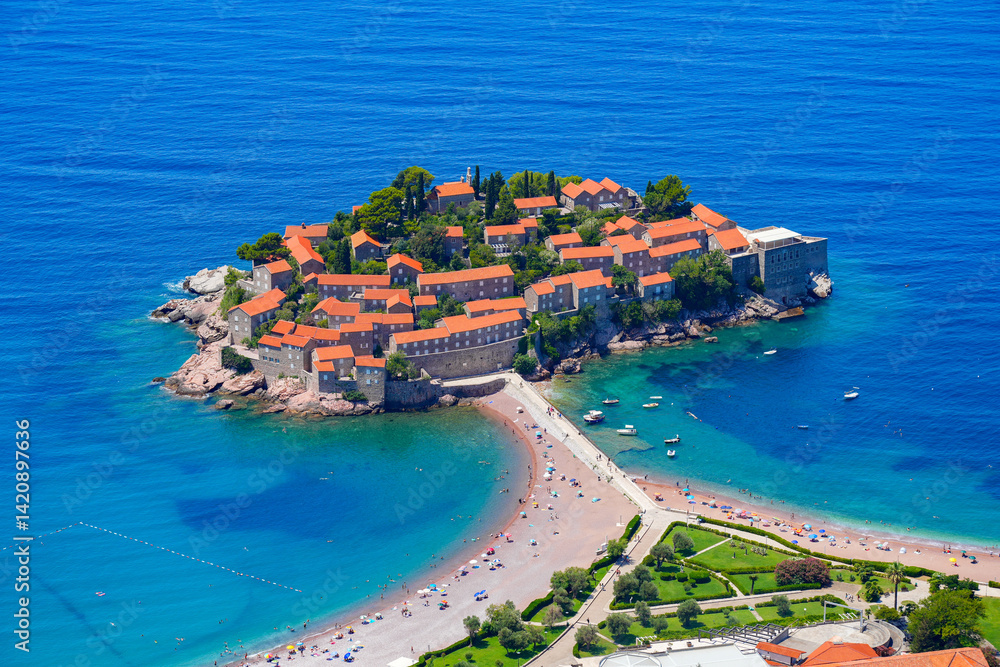Aerial view of Sveti Stefan, a medieval village located on a small island connected to the mainland by a narrow tombolo (sandy isthmus) in the bay of Budva along the Adriatic Coast, Montenegro