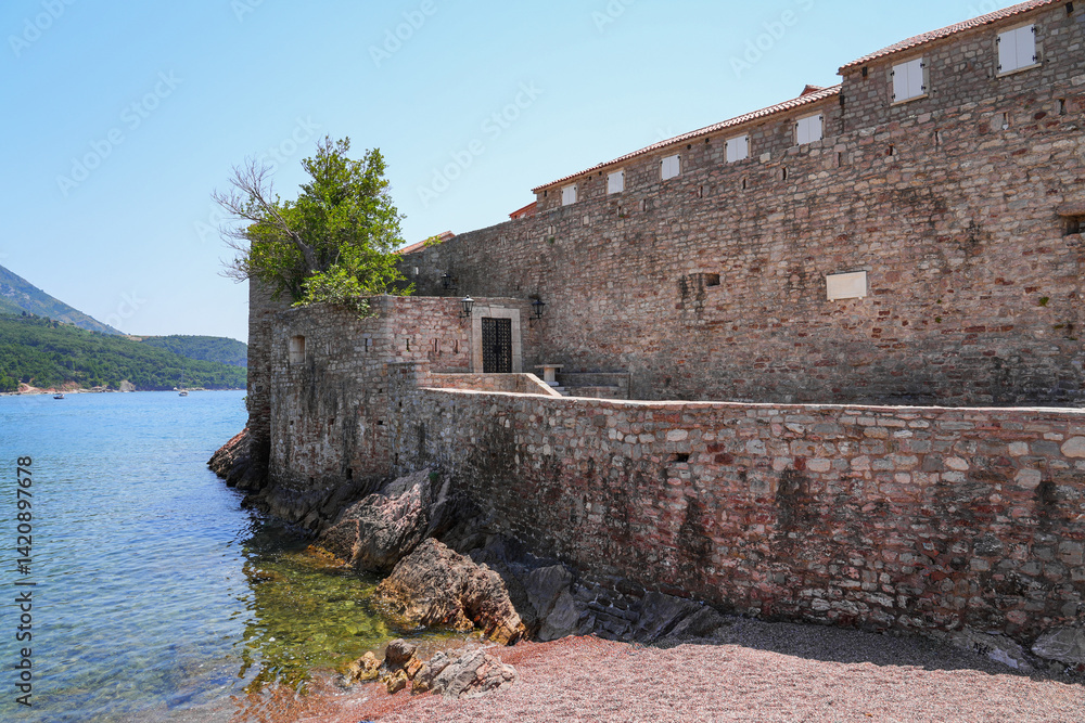Gateway of Sveti Stefan, a medieval village located on a small island connected to the mainland by a narrow tombolo (sandy isthmus) in the bay of Budva along the Adriatic Coast, Montenegro