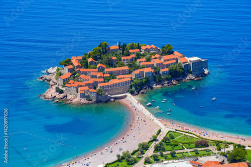 Aerial view of Sveti Stefan, a medieval village located on a small island connected to the mainland by a narrow tombolo (sandy isthmus) in the bay of Budva along the Adriatic Coast, Montenegro