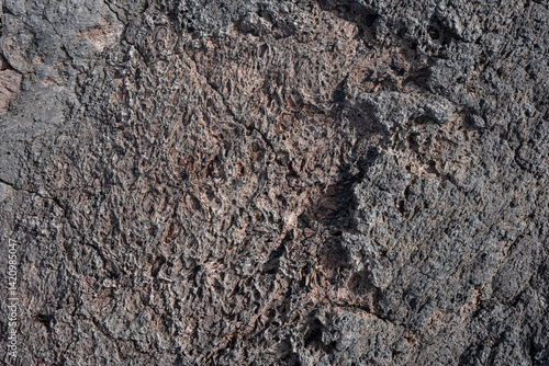Nahaufnahme einer grau-schwarzen Lava-Textur auf dem Boden. Porös, rissig und steinern, ideal als Stock-Textur oder Foto-Hintergrund. Eindruck von geschmolzenem Gestein.