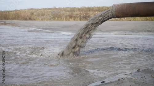 Pollution of the environment by industrial outfalls. Flow of dirty water flows out of the pipe.