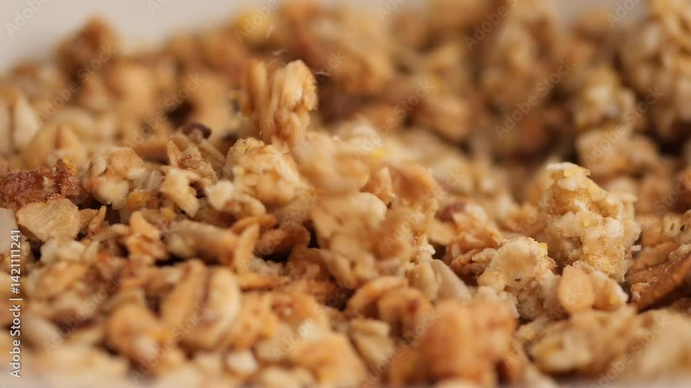 slow motion of granola dropping in a bowl slow motion of granola dropping in a bowl