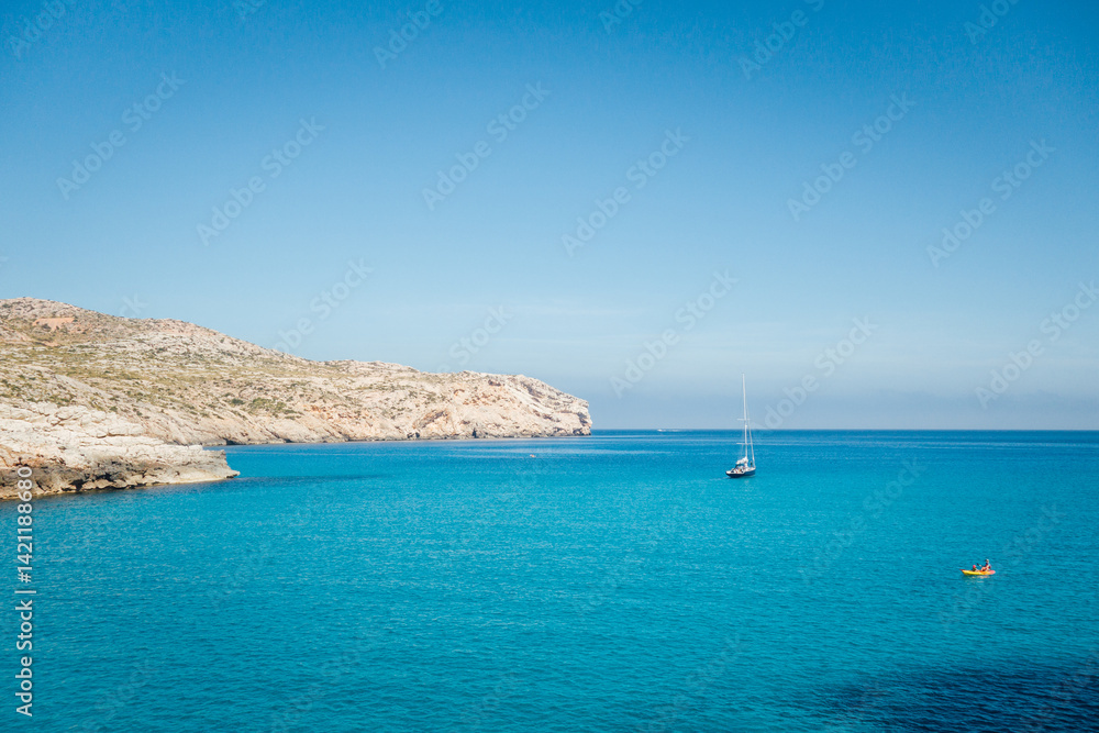 Obraz premium Paysage de Majorque aux Baléares. Mer méditerranée. Kayaking et voilier sur l'eau bleu tropicale. Littoral rocheux et côte sauvage. Loisir de vacances. Bateau de vacanciers. Canoë. Cala Clara Beach
