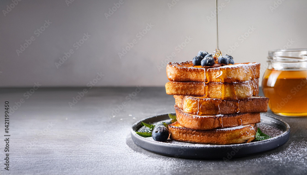 Stack of golden french toasts with syrup, topped with fresh blueberries and mint. Sweet breakfast