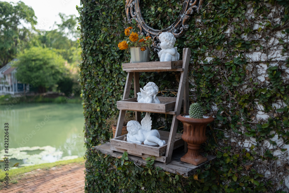 Cupid statue on the wooden shelf in the garden