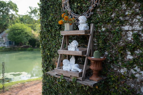 Obraz na płótnie Cupid statue on the wooden shelf in the garden w salonie