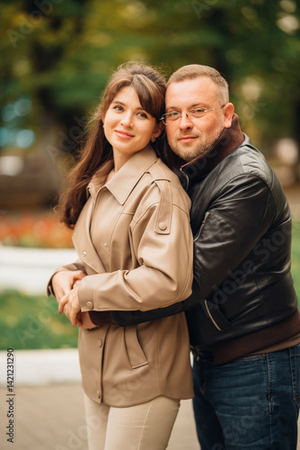 Obraz na płótnie Couple enjoying a sunny day in a park while embracing and posing together w salonie