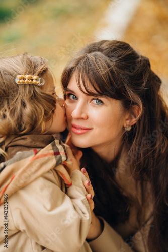 Obraz na płótnie Mother shares a tender moment with daughter in autumn park setting w salonie