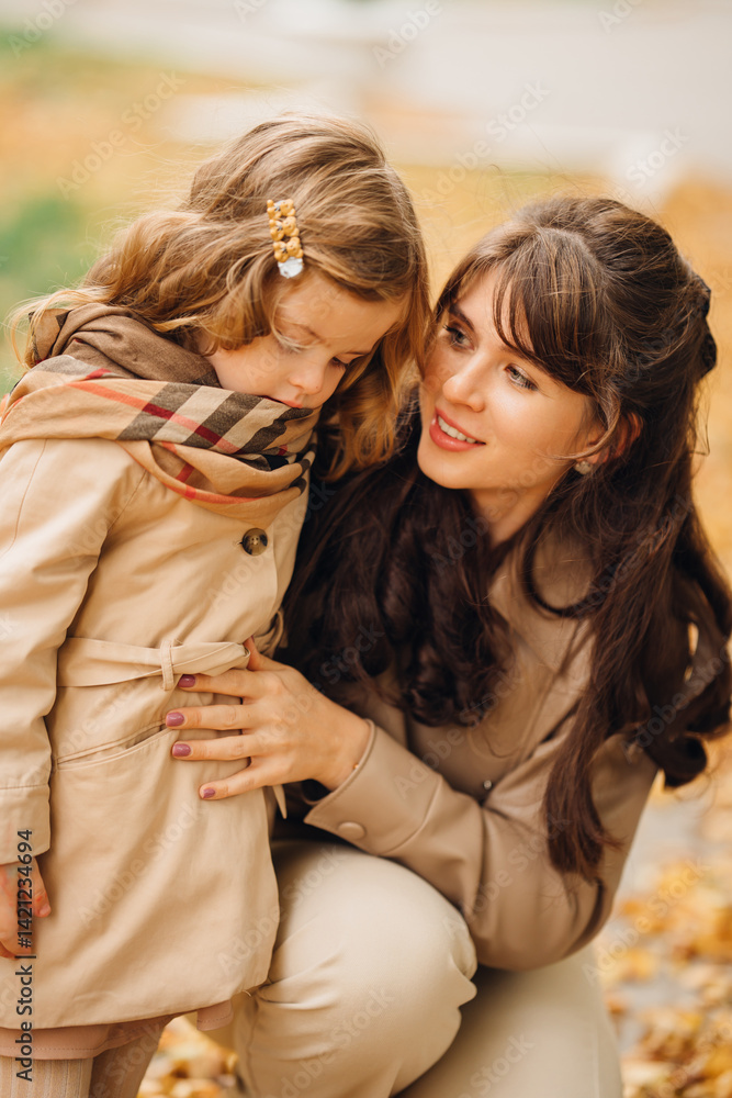 Mother and daughter enjoying an autumn day in a park