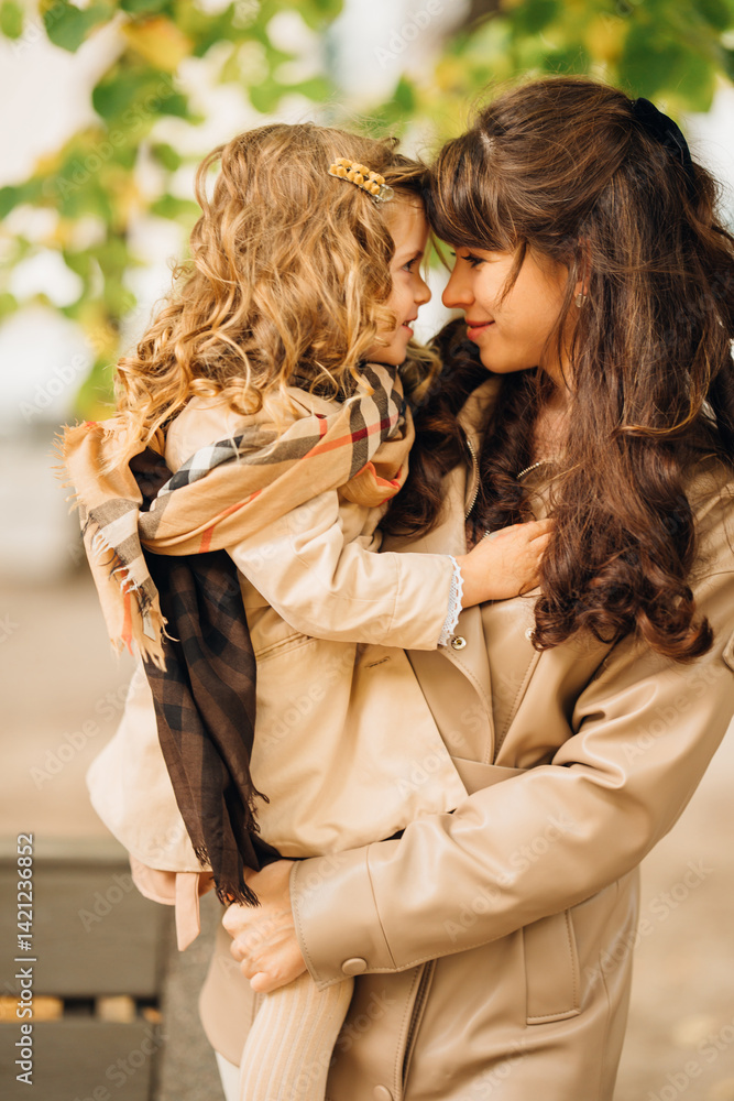 Joyful moment between mother and daughter in autumn park setting