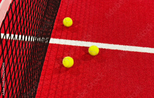 Obraz na płótnie paddle tennis balls near the lines of a red paddle tennis court, racket sports concept w salonie