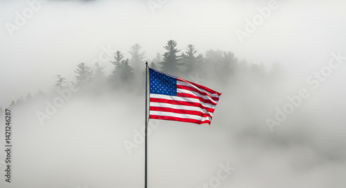 The U.S. flag hanging still in a windless moment, surrounded by dense fog and a forest silhouette.