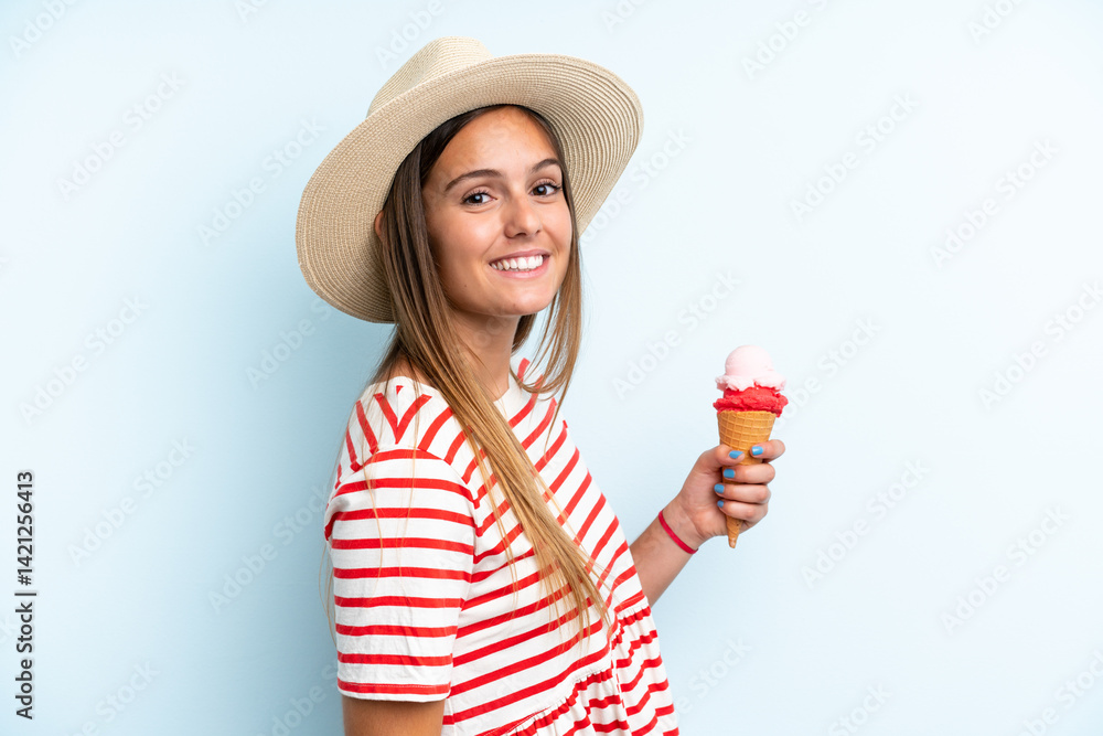 Young caucasian woman holding an ice cream isolated on blue background smiling a lot Young caucasian woman holding an ice cream isolated on blue background smiling a lot