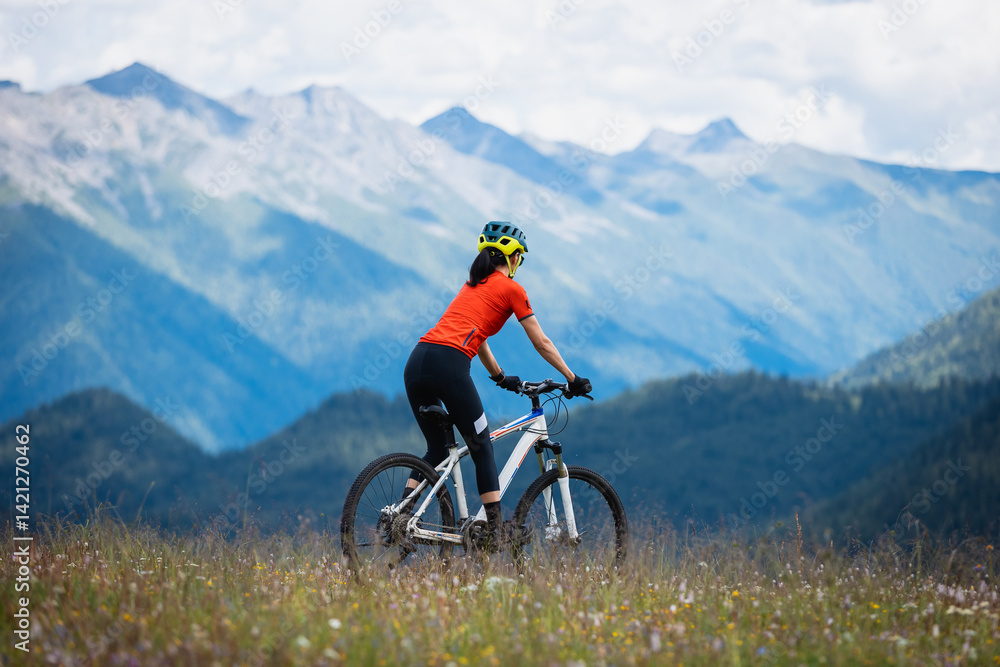 Fototapeta premium Woman riding mountain bike in the beautiful mountains