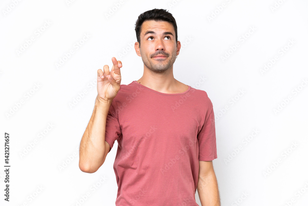 Young handsome man over isolated white background with fingers crossing and wishing the best Young handsome man over isolated white background with fingers crossing and wishing the best