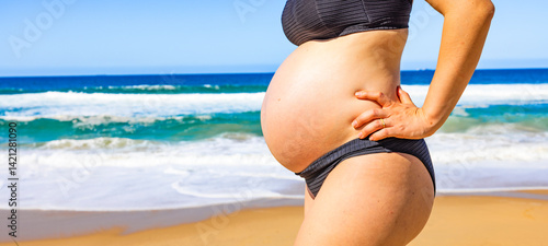Frau mit Babybauch am Srand