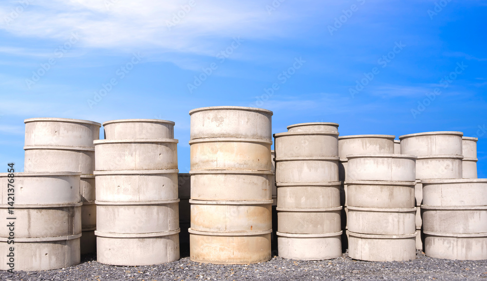 Group of concrete well rings with different diameters stacked on the ground outside of hardware store, front view with copy space Group of concrete well rings with different diameters stacked on the ground outside of hardware store, front view with copy space