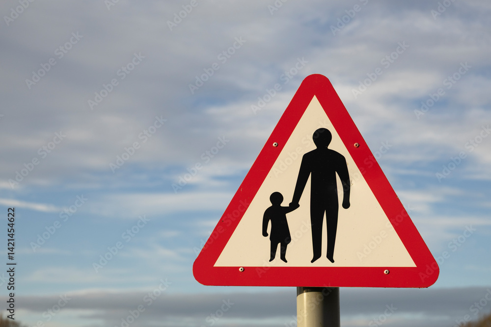 Pedestrians in road ahead sign, close up against a early morning sky Pedestrians in road ahead sign, close up against a early morning sky