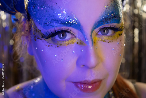 Canvas Print Tropical carnival-inspired makeup with bold blue and yellow tones, glitter, and leaf accessories — a tribute to the blue macaw from Rio in a Cirque du Soleil fantasy style