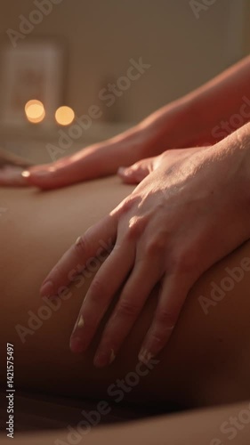 The massage therapist's hands will do a relaxing or wellness close-up massage on a sunny day in slow motion  vertical video