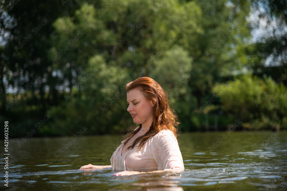 Fototapeta premium Mature woman enjoying a refreshing swim in a serene summer river