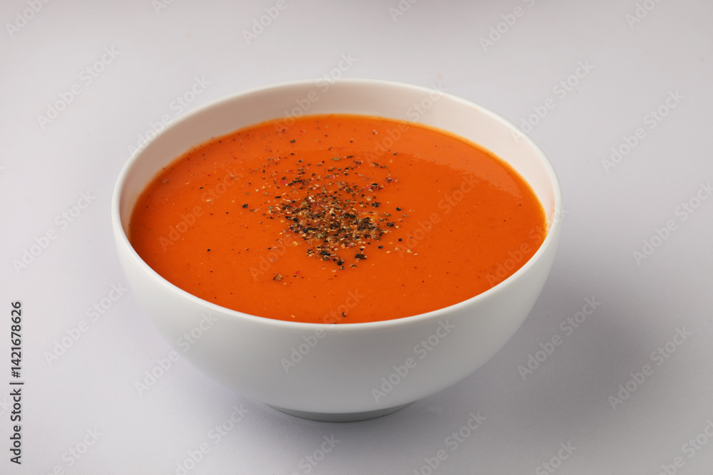 bowl of tomato soup with parsley on white background bowl of tomato soup with parsley on white background