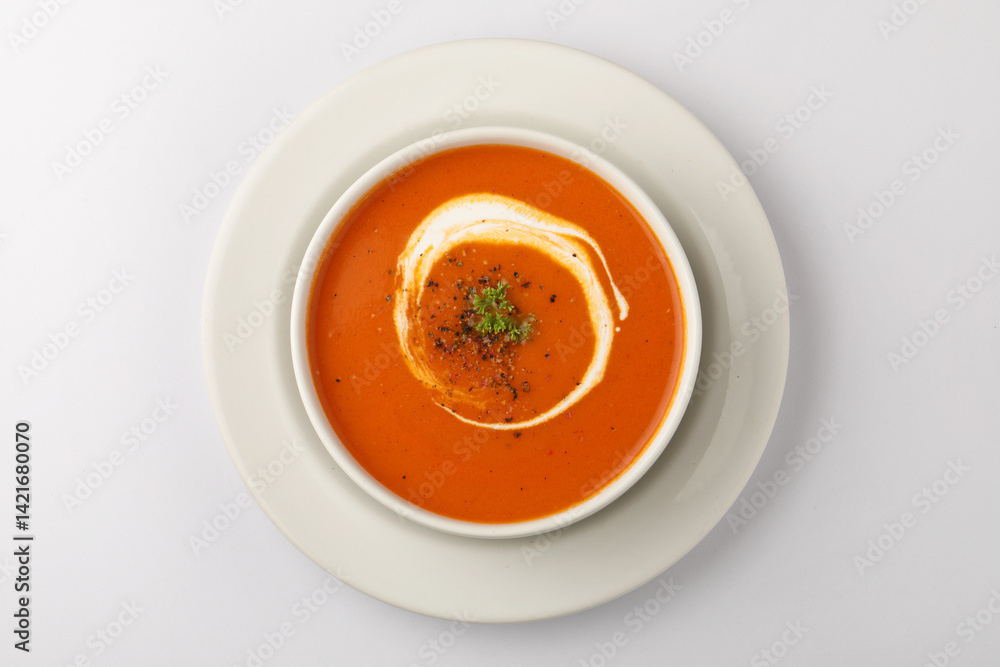 bowl of tomato soup with parsley on white background bowl of tomato soup with parsley on white background