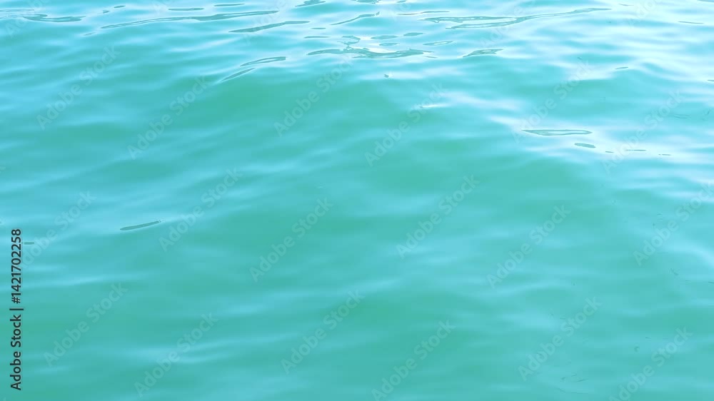 Calm turquoise water surface with gentle ripples reflecting light, creating serene and tranquil atmosphere. Calm turquoise water surface with gentle ripples reflecting light, creating serene and tranquil atmosphere.