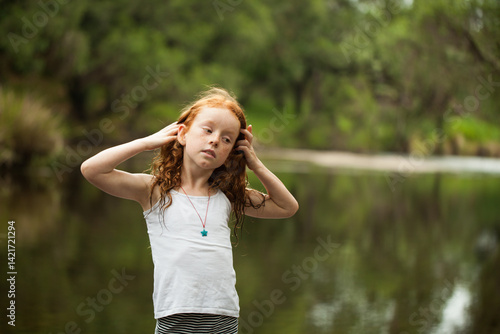 Young redheaded girl by the riverside