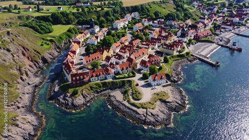 Aerial view of a Danish coastal village in Gudhjem, island of Bornholm, surrounded by water and greenery 