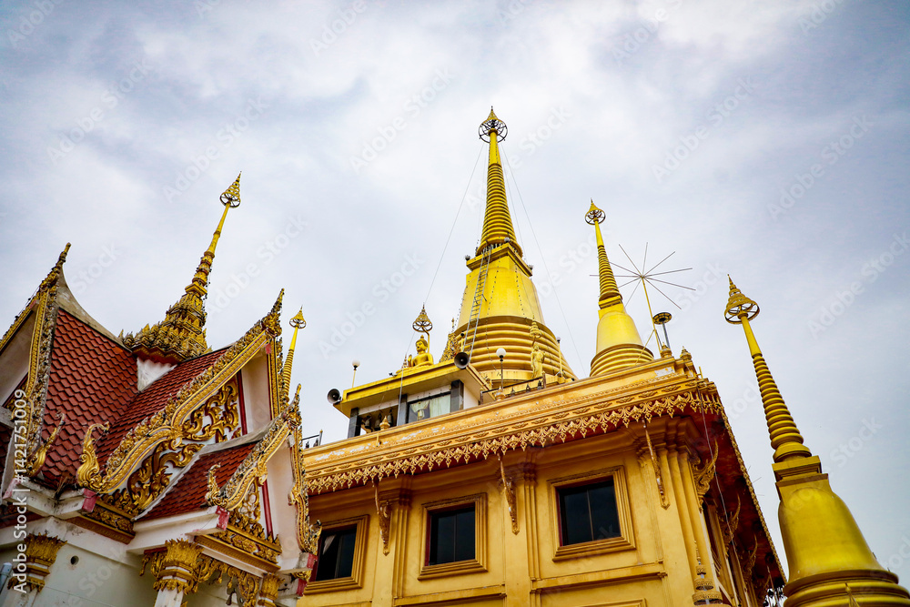 Fototapeta premium Wat Khiriwong, the highlight is the Ubosot and Phra Chulamani Chedi, located on the top of Khao Daowadueng, and offers a high angle view of Nakhon Sawan. It is a beautiful sunset viewing point.