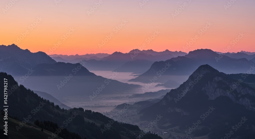 Mountain range view with fog in valley under orange and pink sky. Mountain range view with fog in valley under orange and pink sky.